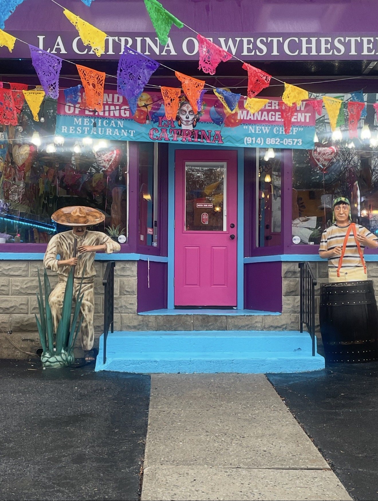La Catrina of Westchester storefront entrance with pink door and colorful papel picado banners